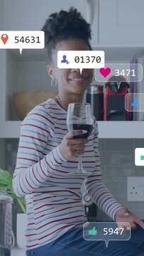 Vertical video: Woman sitting on counter holding wine social bubbles popping counts rising cheering