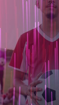 Vertical video: Pulling back player holding soccer ball showing face as pink bars lining team shot