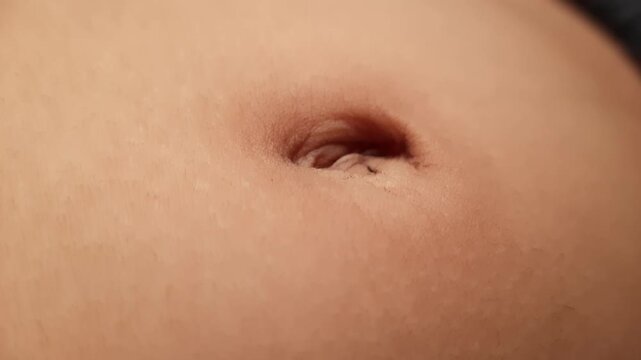 Macro Shot of Child Navel and Belly Showing Natural Breathing Movement with Sharp Skin Detail