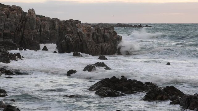 stormy sea meeting rocky coastline of DeKelders, South Africa