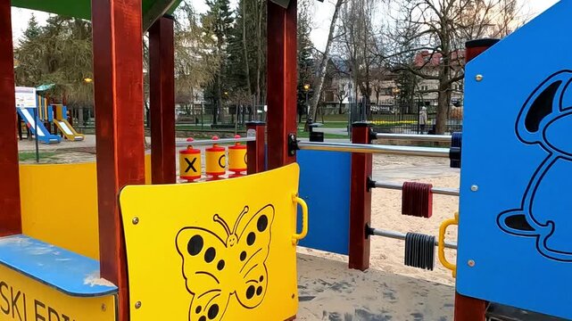 NOWY TARG, POLAND - APRIL 23, 2026: A charming playground with modern equipment on a sand surface.