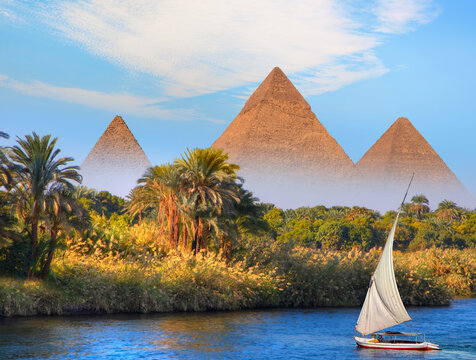 Beautiful Nile scenery with traditional Felluca sailing boat in the Nile on the way to Giza pyramids - Cairo, Egypt