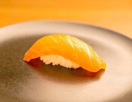 Nigiri de salm&oacute;n fresco sobre plato oscuro con fondo c&aacute;lido minimalista