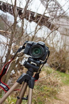 Wylam UK: 13th April 2013: A Canon 7d camera is set on a tripod in a natural area. Branches and plants surround the camera. The scene takes place during the day with clear light