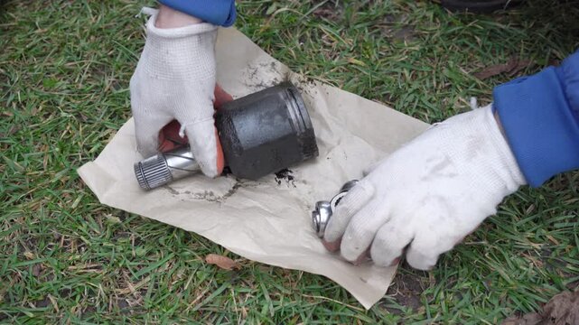 Auto mechanic demonstrates worn and broken CV joint of car, hands of auto mechanic shows the reason for the breakage of the internal CV joint of the car