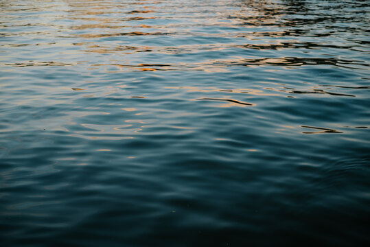 water displays ripples as sunlight reflects off its surface. The scene is set in a natural environment, conveying the beauty of water movement during the day