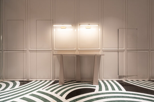 Modern indoor corridor with white walls and green-white wavy patterned floor tiles