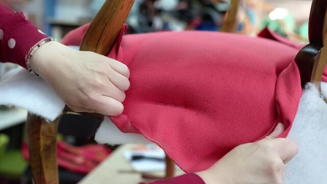 Upholsterer using staple gun to restore vintage chair