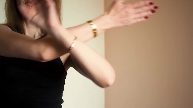 Close up of athletic woman performing cross arm shoulder stretch exercise at home, female athlete practicing upper body flexibility and tension relief during indoor fitness workout