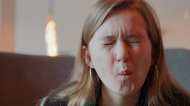 Caucasian woman grimacing at bitter bite, intimate indoor setting with warm lamp glow, closeup facial expressions, hoop earring visible, emotional honest reaction to food, candid portrait with cozy