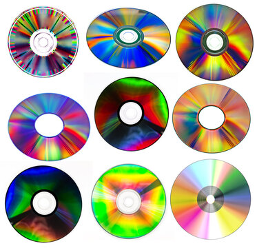 a collection of various compact discs (CDs) or digital versatile discs (DVDs) with reflective, rainbow-colored surfaces