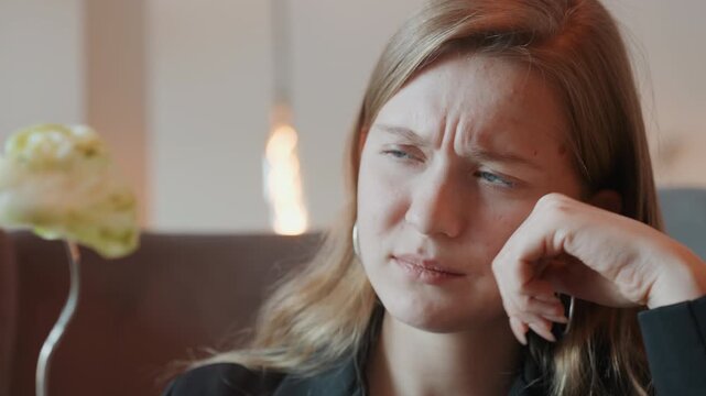 White woman frowning at lettuce fork, reluctant diner evaluating salad during urban caf break, warm lamp light, closeup facial expression showing doubt, subtle tension and hesitation before bite,