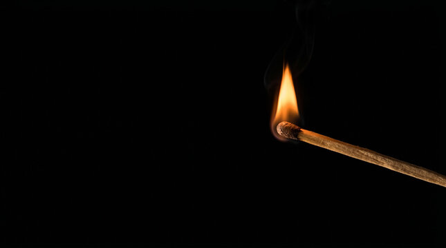 Single lit wooden match flame on pure black background, blackout energy cut power shortage emergency light darkness concept, copy space.