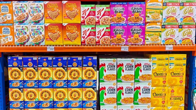 Assorted cereal brands including Cheerios, Kellogg&rsquo;s, and Post for sale at a supermarket shelf