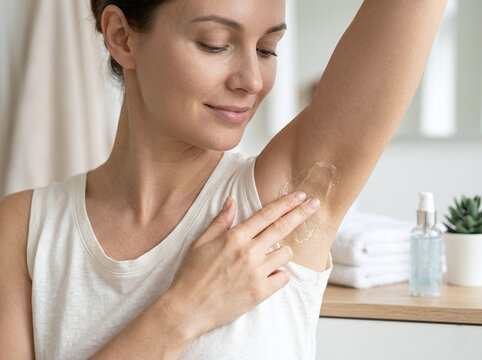 female hand applying moisturizing gel on her armpit, hygiene and beauty concept.