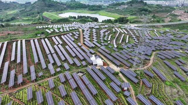 Mountainous photovoltaic power station with terraced solar panel arrays and green landscape