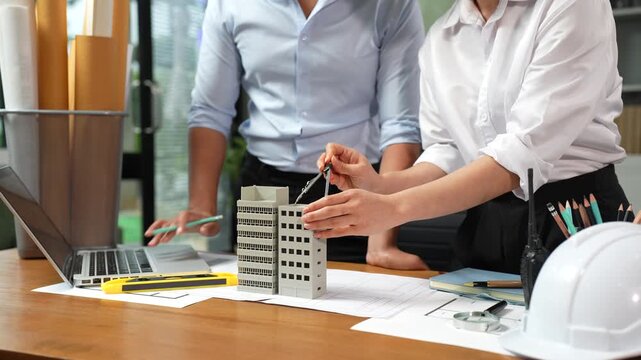 Close up of Engineer teams hands making model house. Engineer teams working in the office.