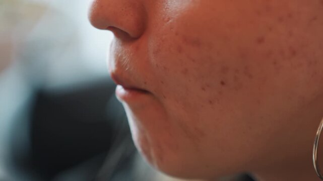 Closeup woman tasting avocado and tomato, slow bite at cafe table, hoop earring glinting, visible skin texture and freckle details, fork approaching lips, gentle chew and contemplative expression,