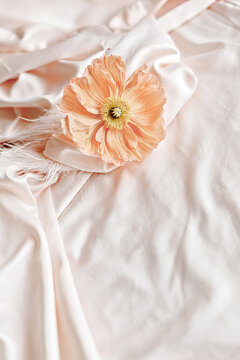 Silk fabric background with poppy flower. Elegant spring background