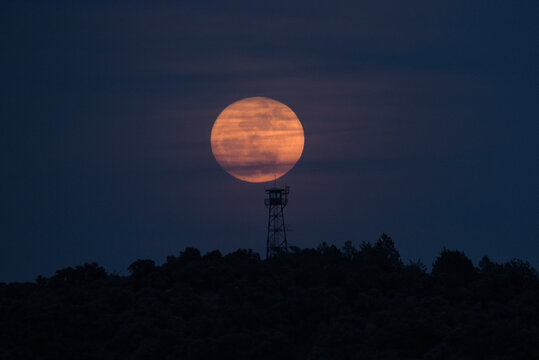 torre de vigilancia forestal con la luna detr&aacute;s