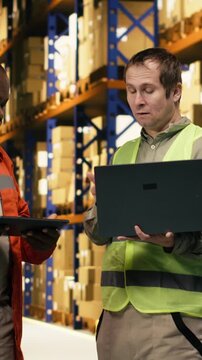 Vertical Video E-commerce colleagues, following packages, on tracking software, using awb tags, tracking info to update the parcel status on tablet and laptop. Overseeing dispatch shipment of