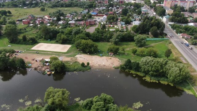 Drone flying backward and rising over river beach