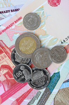 Uzbekistani som money bills and coins on table. Uzbekistan cash of UZS currency close up