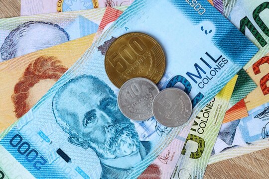Costa Rican colon money bills and coins on table. Costa Rica cash of CRC currency close up