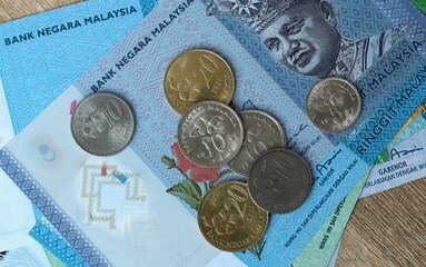 Malaysian ringgit money bills and coins on table. Malaysia cash of MYR currency close up © Larysa