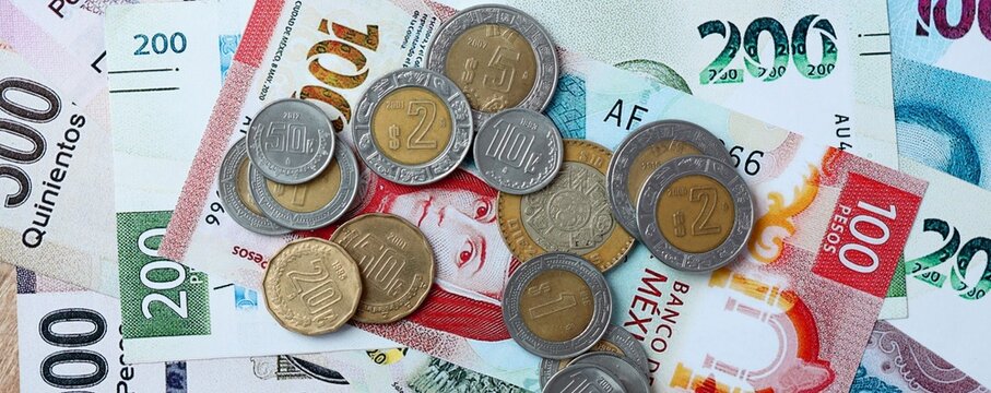 Mexican peso money bills and coins on table. Mexico cash of MXN currency close up