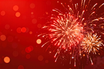 Obraz premium This is a festive red background with sparkling fireworks displays, with soft bokeh light effects creating a warm celebratory atmosphere.