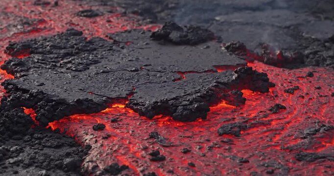 Molten lava flows through volcanic rock during a geological eruption