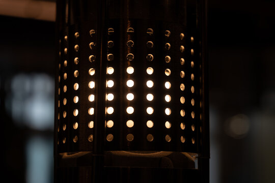 Perforated Metal Lamp Shade Close-up Warm Light Dots Pattern Dark Background