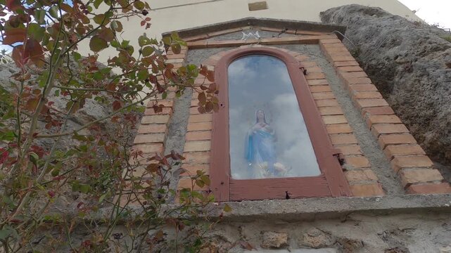 Small statue of the Madonna set in stone, historic center of Castel San Vincenzo, Molise, Italy