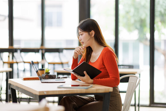 Asian woman student studying online at cafe
