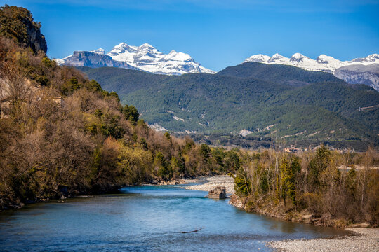 The River Cinca as it flows through Ainsa, Huesca, Aragon, Spain, with the snow-capped peaks of the Pyrenees in the background