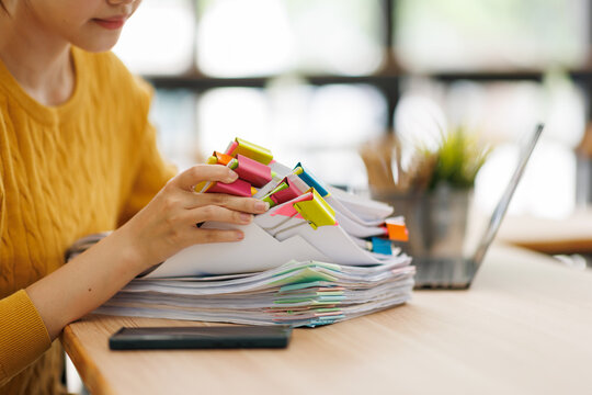 Woman organizing a stack of documents with colorful binders