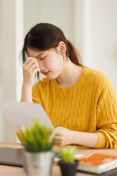 Asian woman experiencing headache from work stress