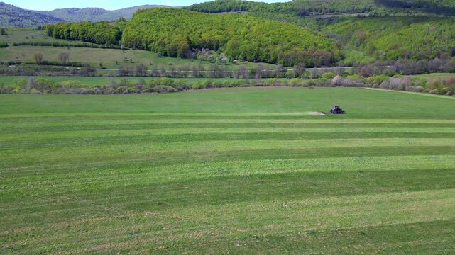 Aerial shot of a tractor plowing the land, preparing the field for cultivation