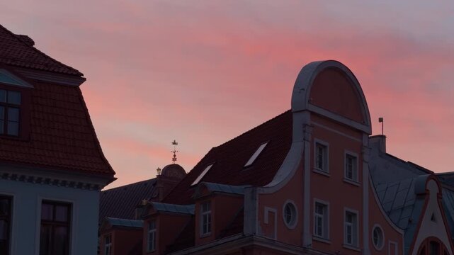 Calm skyline during evening dusk. Evening horizon shows historic rooftops in soft glow. Sunset scenery captures tranquil urban rooftops with pastel hues and gentle atmosphere