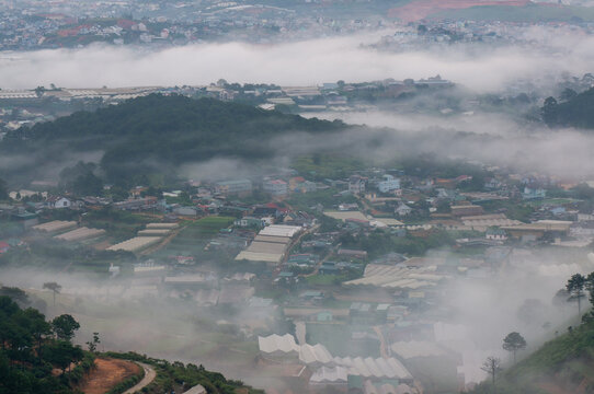 The view of Da Lat from Du Sinh Cemetery towards the city center. Da Lat on a morning shrouded in mist and early sunlight, a magical morning light. Beautiful Vietnamese scenery.