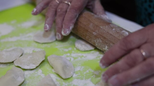 Close up of hands making traditional homemade dumplings with cottage cheese