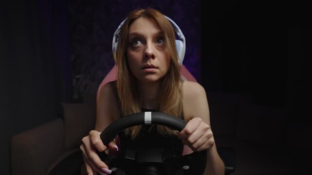 Startled Gaming Reaction White Woman Gripping Wheel And Headset, Pink Chair Lit By Purple Studio Light, Wide