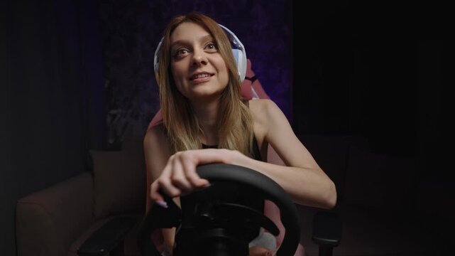 Interactive Sim Streamer White Woman Coaching Viewers Live With Headset And Steering Wheel, Demonstrating