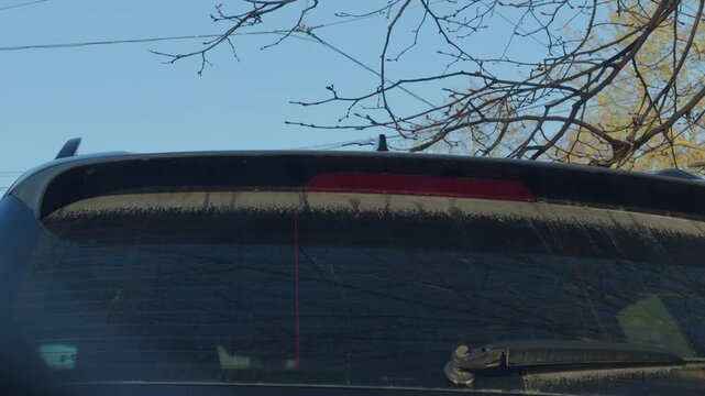 Frosted vehicle dawn. Suburban car under icy morning. Morning frost on parked hatchback. Quiet suburban scene featuring icy windshield and delicate morning frost patterns