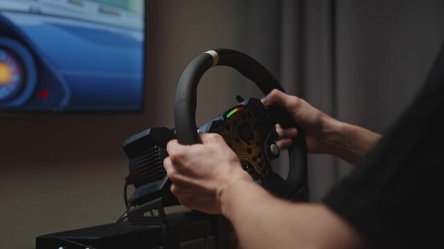 Hands configuring racing wheel and pedals on sim rig, closeup of fingers, calibration and hardware alignment in living room setup
