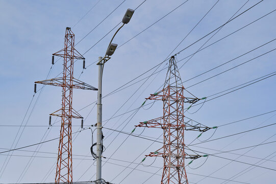 Power lines and street lamps under a clear blue sky in an urban setting