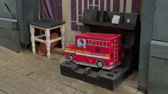 Decorative small delivery vehicle scene. Compact delivery truck on display with promotional branding. Smallscale delivery van showcased on pallet amidst store environment features