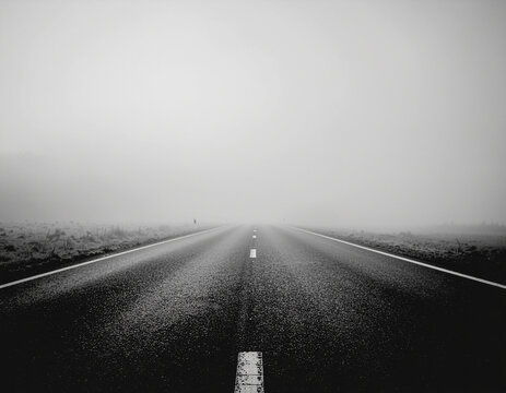 lonely road fading into dense fog representing unknown future and direction