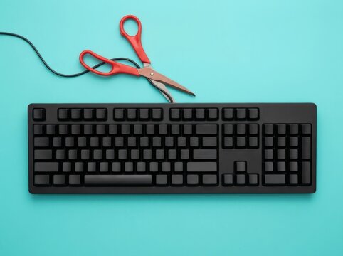 Black Computer Keyboard With Red Scissors On Turquoise Background.